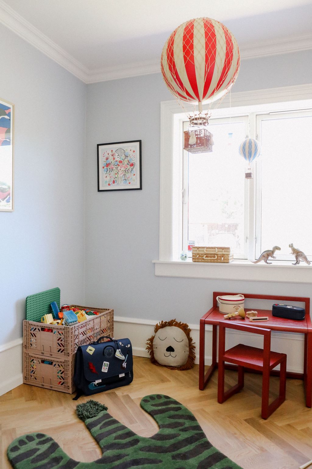 Børneværelse med vægdekoration, legetøj, skrivebord og luftballonlamper