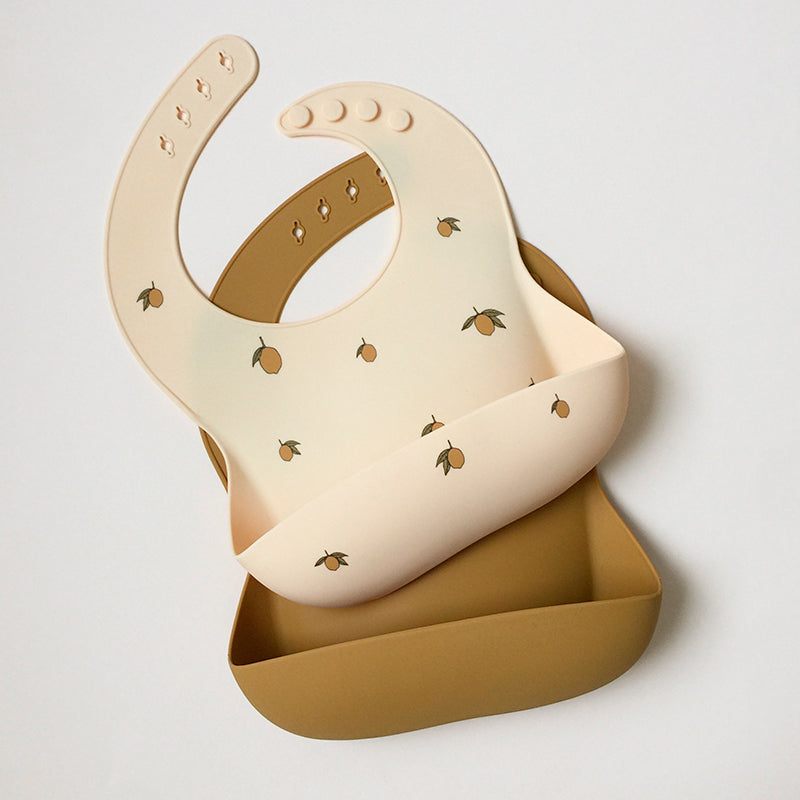 Konges Sløjd silikonhaklapp med ficka, 2-pack - Lemon/almond